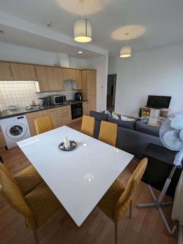 een keuken en een woonkamer met een witte tafel en stoelen bij 2 bedroom apartment in Gravesend 10 mins walk from train station with free parking in Gravesend