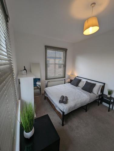 een slaapkamer met een bed in een kamer met een raam bij 2 bedroom apartment in Gravesend 10 mins walk from train station with free parking in Gravesend