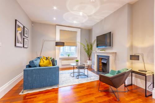 a living room with a blue couch and a fireplace at Luxury Spacious Flat For 4 Guests & Free Parking in Nottingham