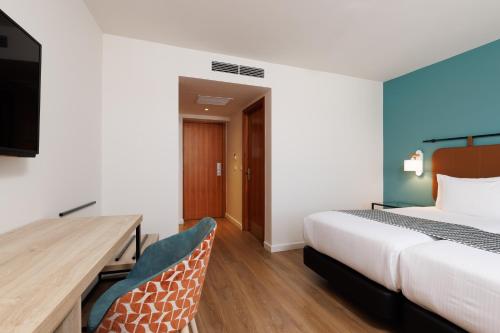 a hotel room with a bed and a desk and chairs at Exe Vienna in Vienna