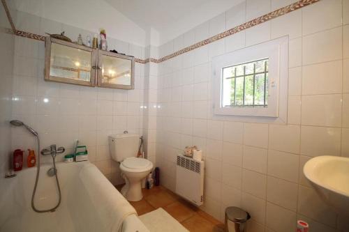 een badkamer met een bad, een toilet en een wastafel bij Valbonne - Villa dans le domaine privé Val d'Azur avec piscine, tennis in Valbonne