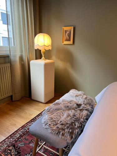 um quarto com uma cama e um candeeiro sobre uma mesa em Belvedere Suite Verdant em Viena