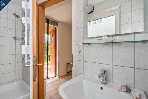 a bathroom with a white tub and a sink at Ferienresort Möwenort Lütow Bungalow 6 in Lütow