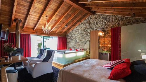 a bedroom with a large bed and a bath tub at Casa do Zuleiro in Brion de Arriba