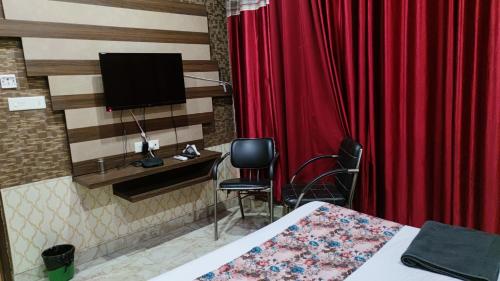 um quarto com uma cama e uma cortina vermelha em Swastik Vatika em Ambala