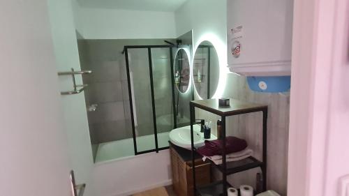 une salle de bain avec une douche en verre et un lavabo dans l'établissement Plein Soleil, à Saint-Jean-de-Monts