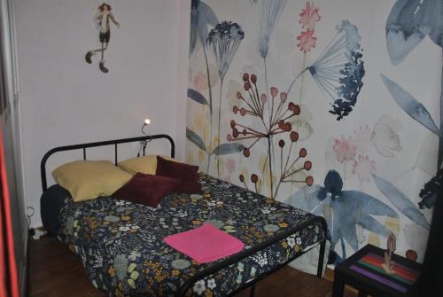 - une chambre avec un lit et un papier peint floral dans l'établissement la loire et ses chateaux, à Montlouis-sur-Loire