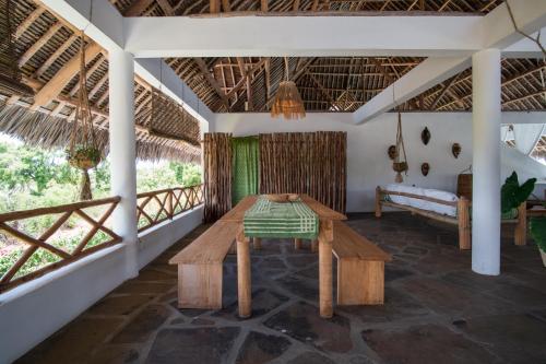 a room with a table and a couch on a porch at Rafiki Tamu Residential Resort in Watamu
