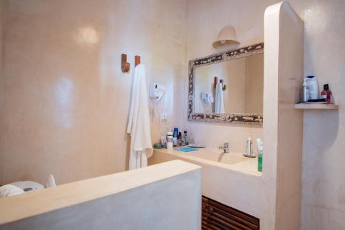 a bathroom with a sink and a mirror at Rafiki Tamu Residential Resort in Watamu