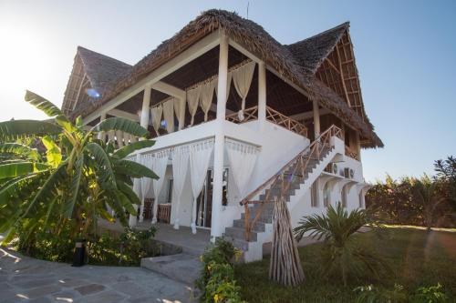 a house with a staircase in front of it at Rafiki Tamu Residential Resort in Watamu