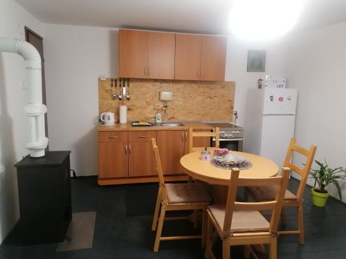 a small kitchen with a table and a white refrigerator at Kuća za odmor Ke ti je in Velika Gorica
