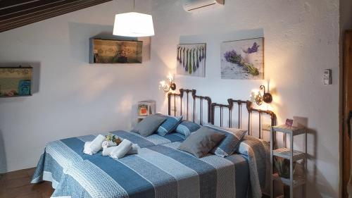 a bedroom with a blue bed with pillows on it at Molino Los Justos - Casa Vieja- Algarinejo by Ruralidays in Algarinejo