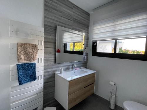 ein Bad mit einem Waschbecken und einem Spiegel in der Unterkunft Casa Albera contemporaine piscine vue montagne in Laroque-des-Albères