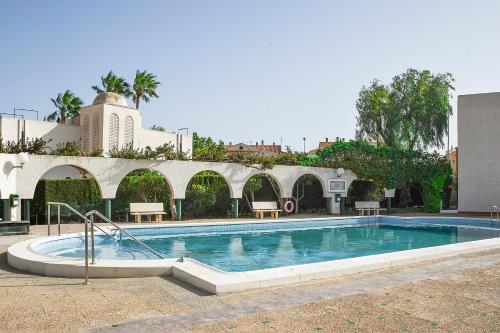 una piscina en un patio con un edificio en La Casa de las Maravillas, en Puerto de Mazarrón