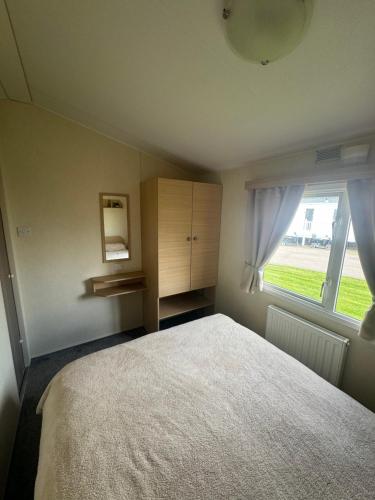 a bedroom with a bed and a window at Atlas festival in Leysdown-on-Sea