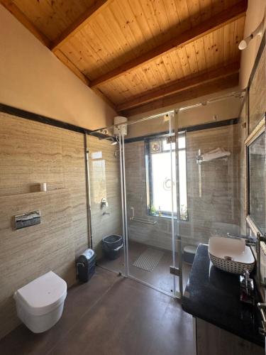 a bathroom with a shower and a toilet and a sink at NATURE NEST HOMESTEAD in Baihar