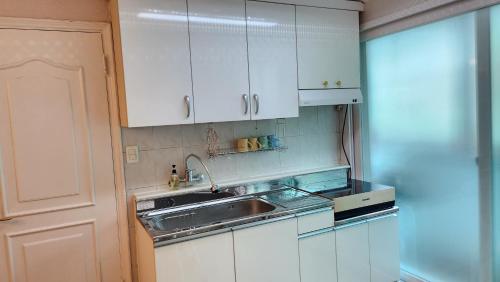 a kitchen with white cabinets and a sink at 2room with 4beds near kintex daehwa station in Goyang