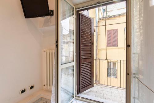 una porta scorrevole in vetro che si apre su un balcone in una stanza di Redseven Rome Apartment a Roma