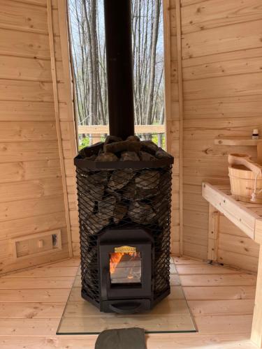 a fireplace in a log cabin with a window at Bunkier House in Niedźwiada