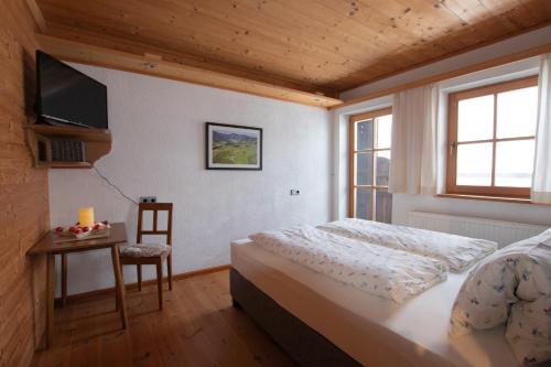 1 dormitorio con cama, mesa y TV en Neuhaus-Hof by FeWo-PLAN REIT100, en Reith im Alpbachtal