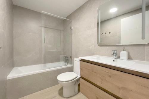 a bathroom with a toilet and a sink and a tub at Apartamento Boutique en el corazón de Ronda in Ronda