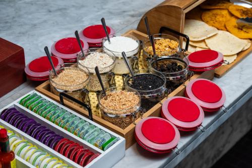 a buffet with plates and bowls of food on a table at Hotel Holiday Inn Express & Suites Medellin by IHG in Medellín