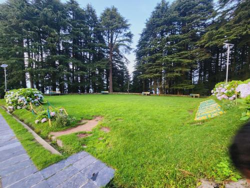 a large grassy field with trees in the background at SmartValley View Dalhousie-Nature`s Heaven in Dalhousie