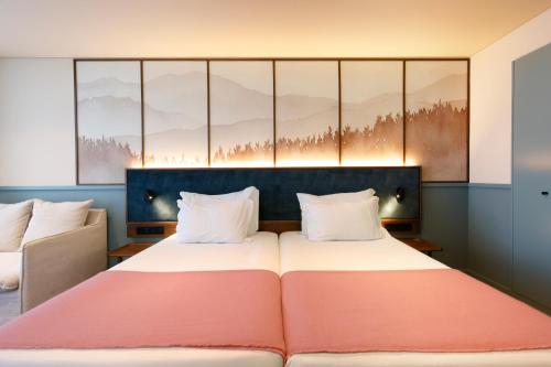 a bedroom with a large bed with a red blanket at Montebelo Viseu Congress Hotel & Spa in Viseu