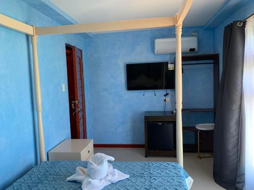 a bedroom with a bed with a blue wall at La Salangane Beach Hotel - Downtown in El Nido