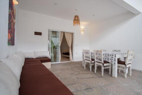 a living room with a table and chairs and a couch at Rafiki Tamu Residential Resort in Watamu