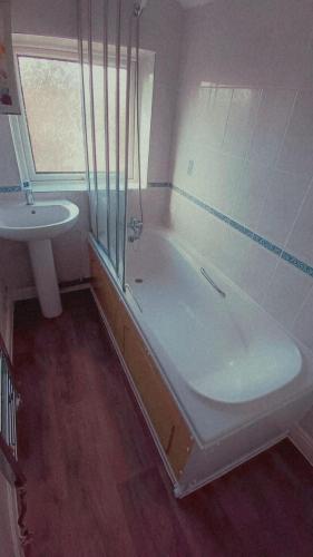 a bathroom with a shower and a tub and a sink at Instant Lodge in Leicester