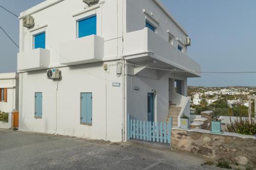 a white house with blue windows and a driveway at Μπαλκόνι με θέα / Viewtiful balcony in Adamas