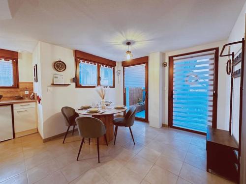 une cuisine et une salle à manger avec une table et des chaises dans l'établissement Escape Appart' - Le Nautilus, à Rhinau