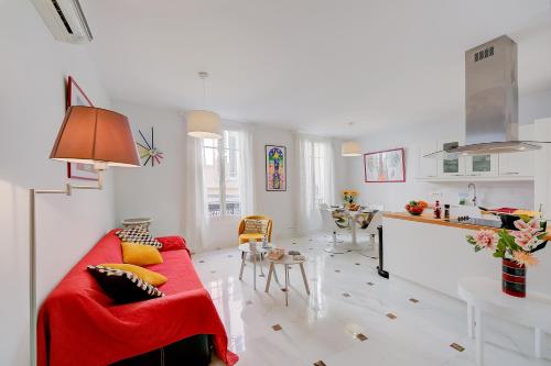 un soggiorno con divano rosso e una cucina di Appartement Picasso - Vieil Antibes - Happy Rentals a Antibes