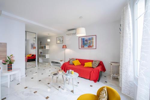 un soggiorno con divano rosso e tavolo di Appartement Picasso - Vieil Antibes - Happy Rentals a Antibes