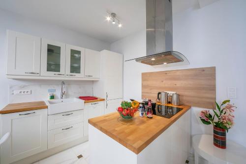 a kitchen with white cabinets and a wooden counter top at Appartement Picasso - Old Town Antibes - Happy Rentals in Antibes