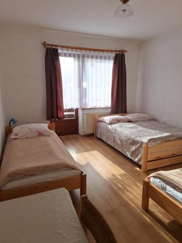 1 dormitorio con 2 camas y ventana en OŚRODEK WCZASOWY GERLACH., en Białka Tatrzanska