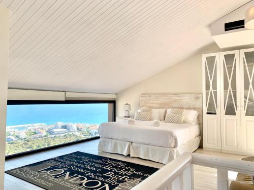 a bedroom with a bed and a large window at Sitges Spaces Sea View Villa- 6 Bedrooms, 5 bathrooms, 2 private pools, Near center in Sitges