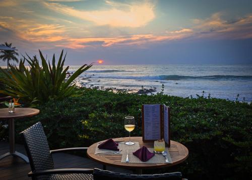 a table with a glass of wine on the beach at The Inn Manzanillo Bay in Troncones