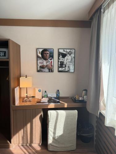 a desk in a room with two pictures on the wall at Hôtel Rallye & Entrées aux Bains de la Gruyère in Bulle