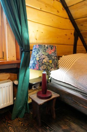 a bedroom with a bed and a table with a lamp at Ранчо Скарбова Гора in Selisko