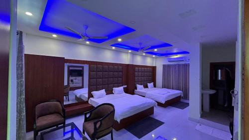 - une chambre avec 2 lits et des lumières bleues au plafond dans l'établissement ELITE MANDARMONI, à Mandarmoni