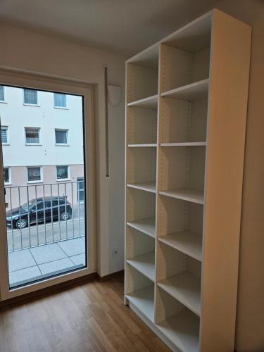 estante de libros en una habitación con ventana en State of the Art Apartment in the City Center Nürnberg, en Núremberg