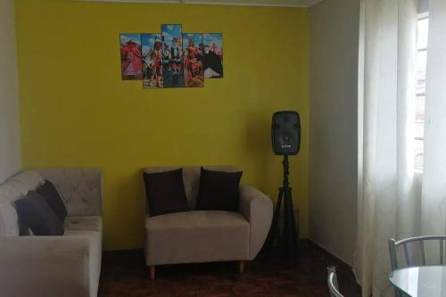 sala de estar con sofá y TV en la pared en Alojamiento en Jauja - Céntrico, en Jauja