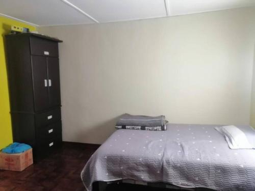 1 dormitorio con 1 cama y armario negro en Alojamiento en Jauja - Céntrico, en Jauja