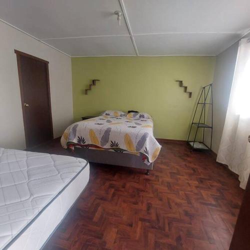1 dormitorio con 1 cama y suelo de madera en Alojamiento en Jauja - Céntrico, en Jauja