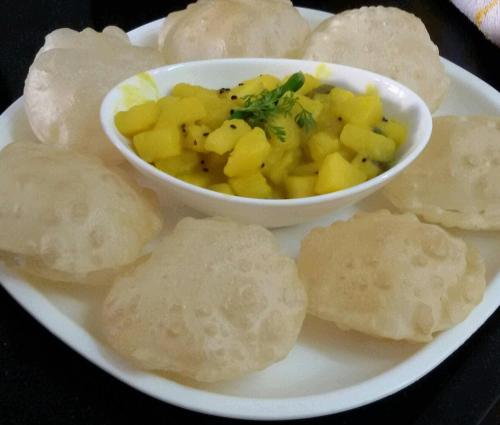 a plate of food with a bowl of fruit and chips at Royal Paying Guest in Kolkata