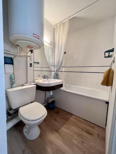 une salle de bain avec toilettes, lavabo et baignoire dans l'établissement Les pieds dans le sable, à Cabourg