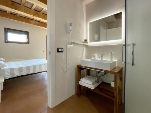 a bathroom with a sink and a bed at Casale dei Cinque Colli in Ostra