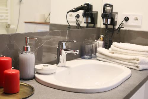 a bathroom counter with a sink and two red candles at Praga Premium Comfort in Warsaw